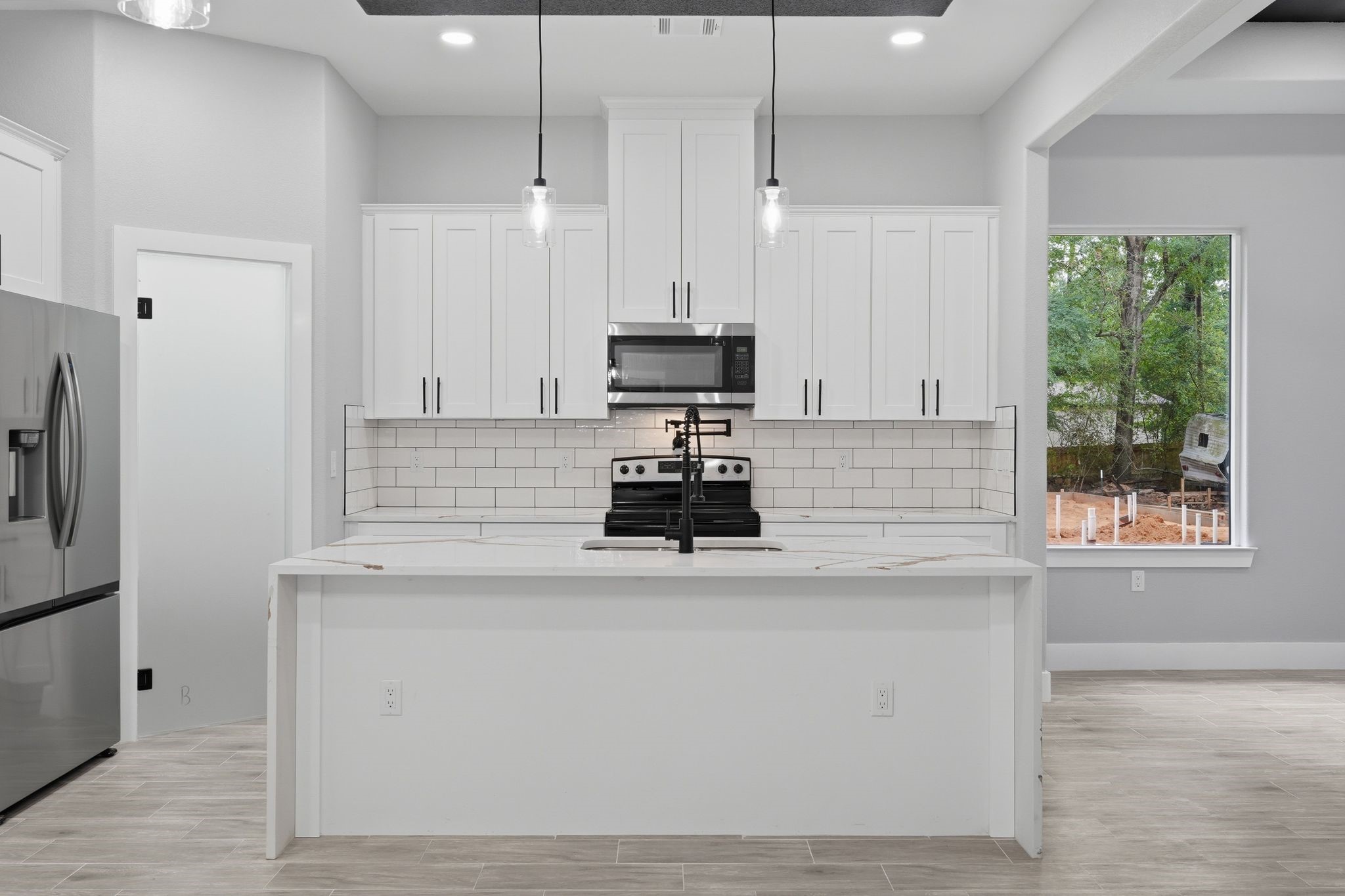 3575 Roy Bean Road Willis, TX 77378 - Photo 14 of 40 a kitchen with kitchen island white cabinets and window
