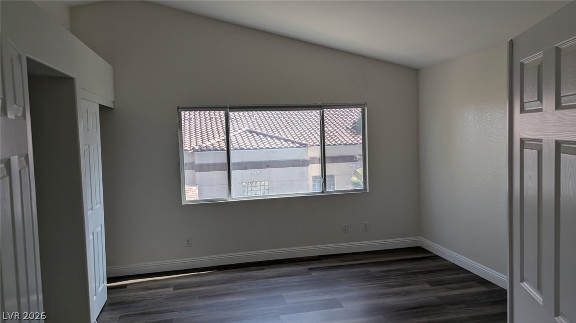 2670 Ridgewater Circle Henderson, NV 89074 - Photo 17 of 22 This airy bedroom features vaulted ceilings and rich wood flooring, creating a comfortable and inviting atmosphere.