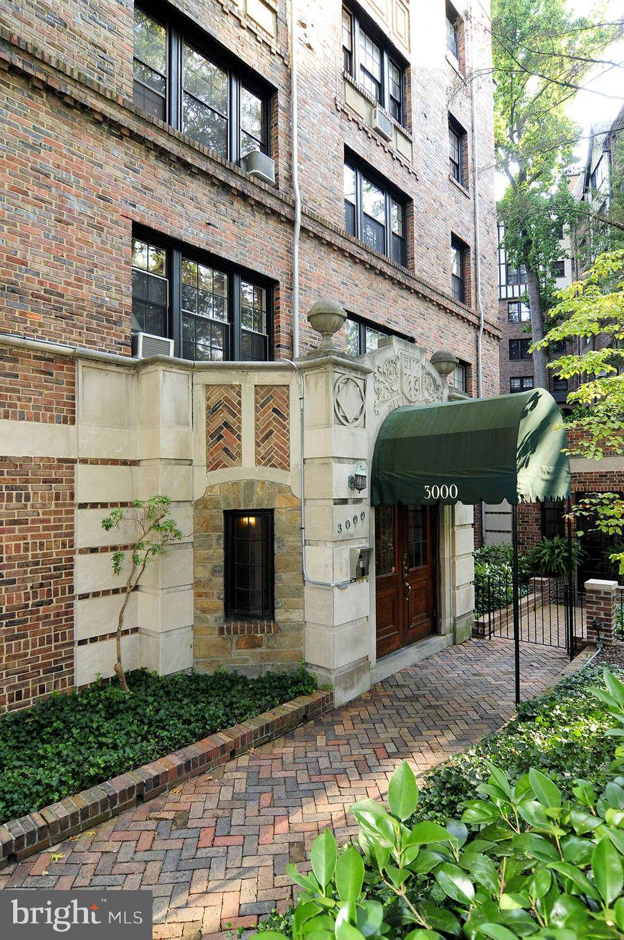 a front view of a building with a garden