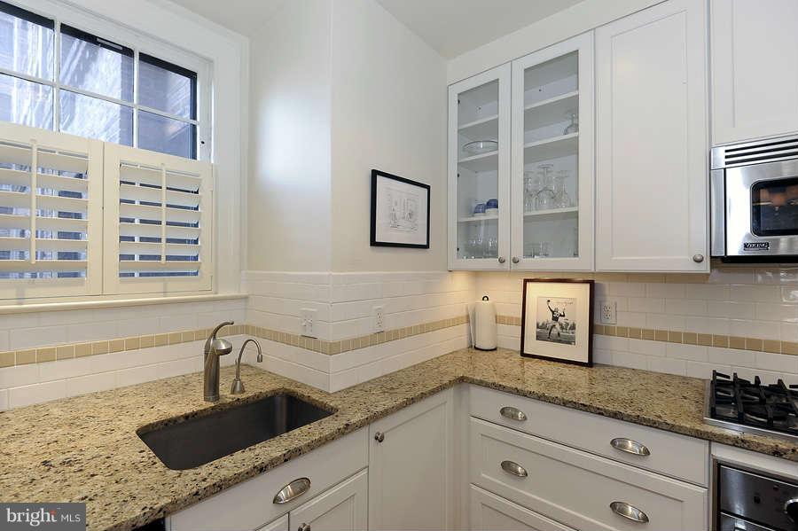 3000 Tilden Street Northwest, Unit 102 Washington, DC 20008 - Photo 11 of 29 a kitchen with granite countertop a sink a stove and cabinets