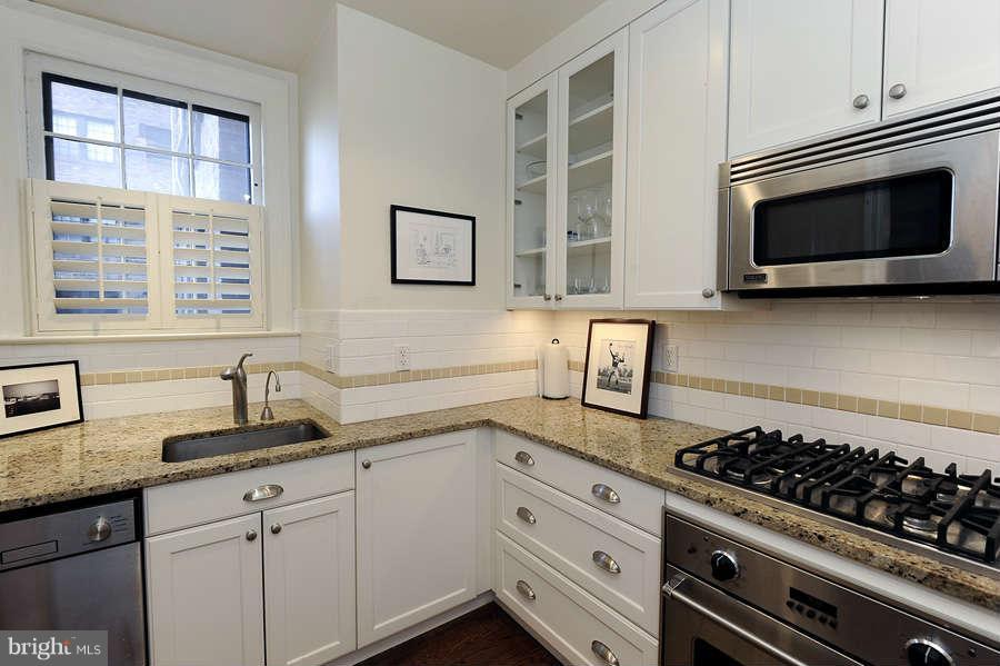 3000 Tilden Street Northwest, Unit 102 Washington, DC 20008 - Photo 13 of 29 a kitchen with stainless steel appliances a stove a sink and a microwave
