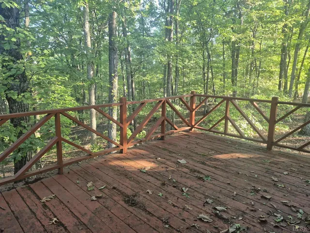 a view of roof deck with large trees and wooden fence
