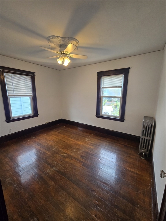 70 Montcalm Avenue, Unit 2 Boston, MA 02135 - Photo 3 of 8 a view of an empty room with wooden floor and a window