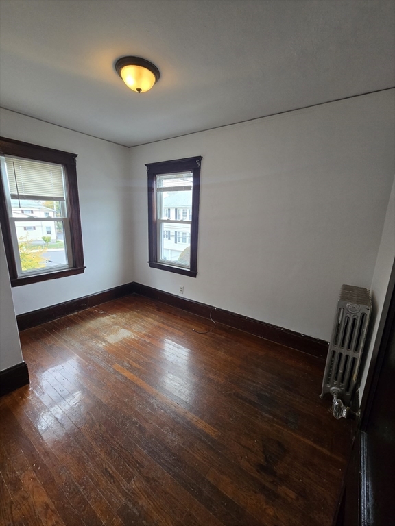 70 Montcalm Avenue, Unit 2 Boston, MA 02135 - Photo 4 of 8 an empty room with wooden floor and windows