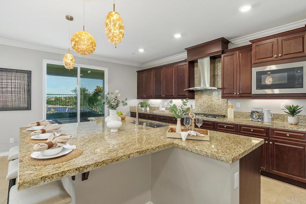 33802 Edge Lane Temecula, CA 92592 - Photo 11 of 31 a kitchen with stainless steel appliances granite countertop a sink a stove and a wooden cabinets