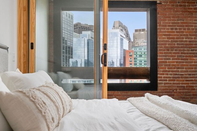 a bedroom with a bed and a flat tv screen next to a window