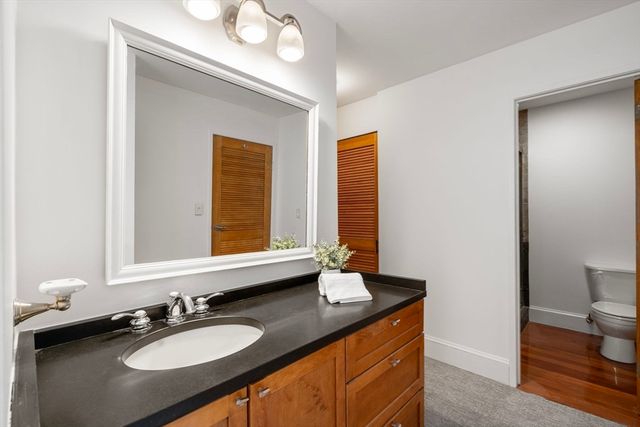 a bathroom with a granite countertop sink and a mirror