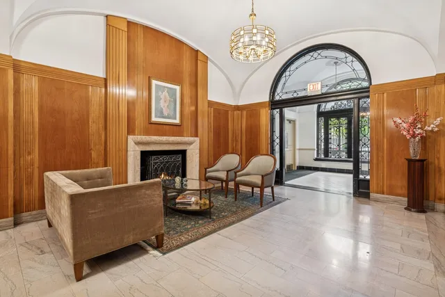 a living room with furniture a fireplace and chandelier