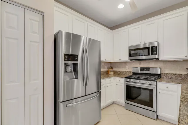 a kitchen with stainless steel appliances white cabinets and a refrigerator