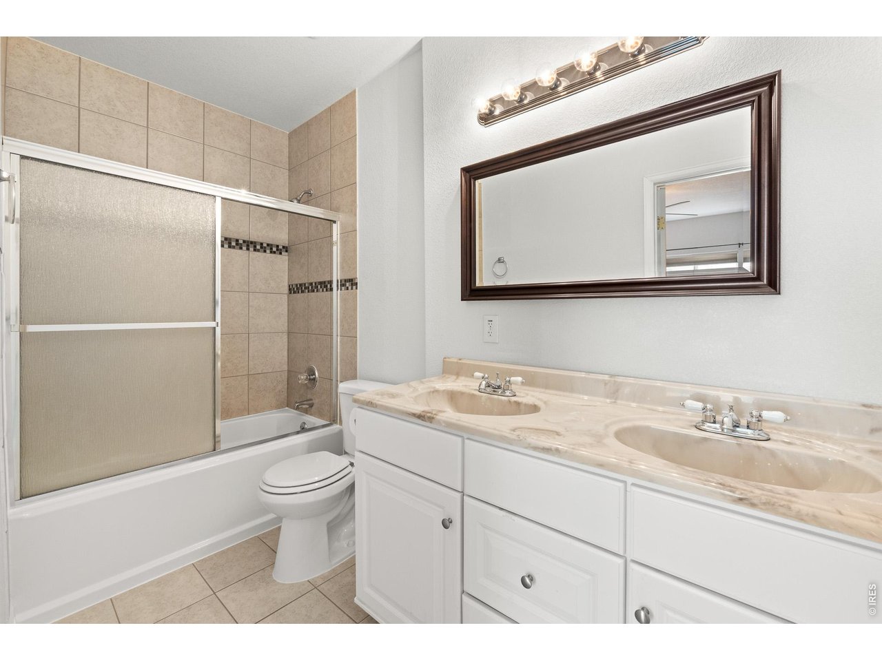 5726 Graphite Street Timnath, CO 80547 - Photo 35 of 49 a bathroom with a toilet a sink a vanity and mirror