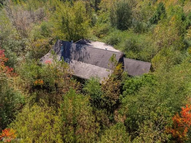an aerial view of a house with a yard and tree s