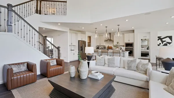 a living room with furniture kitchen view and a chandelier