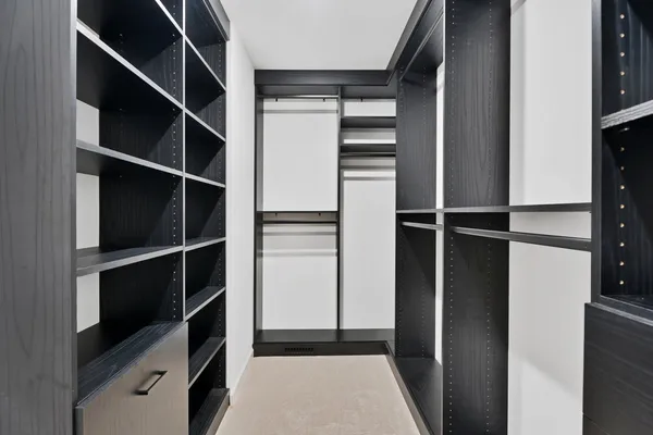a view of walk in closet with empty racks