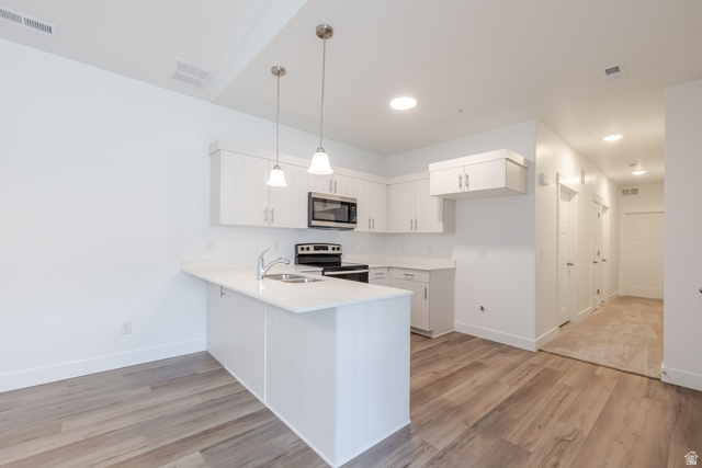 693 West 4500th South, Unit O303 Mapleton, UT 84664 - Photo 12 of 15 Kitchen featuring white cabinets, light wood-type flooring, stainless steel appliances, and a peninsula