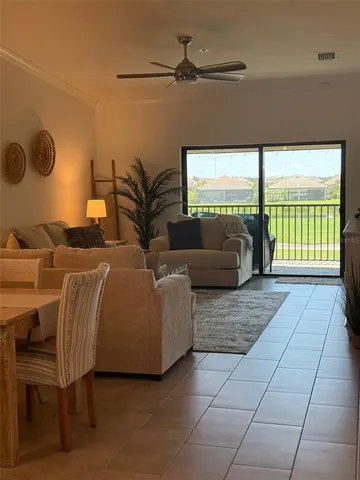 a living room with couches bookshelf and a large window