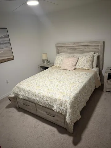 a bed sitting in a bedroom next to a lamp