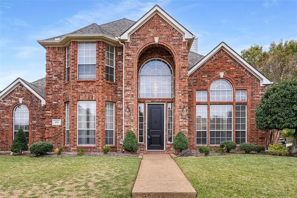 front view of a brick house with a yard