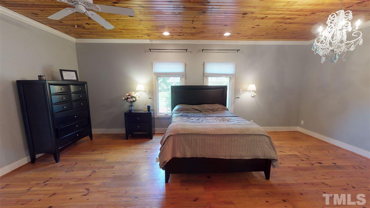 3509 Bahama Road Rougemont, NC 27572 - Photo 15 of 30 a bedroom with a bed and a chandelier