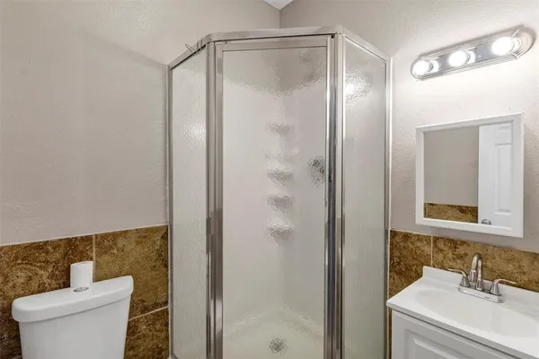 a bathroom with a granite countertop sink toilet and shower