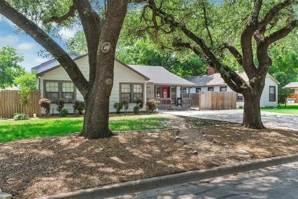 a view of a house with a tree in the yard