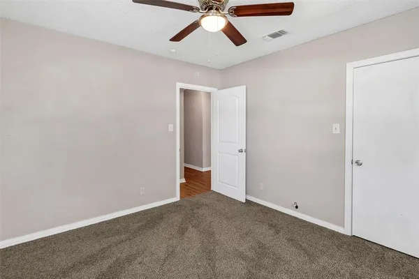 an empty room with chandelier fan