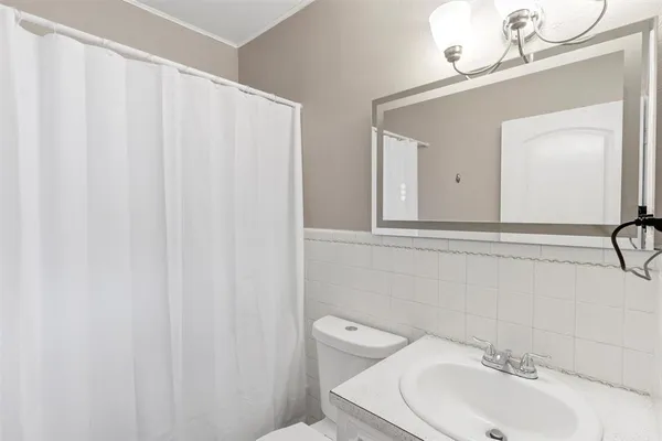 a bathroom with a sink a toilet and a mirror