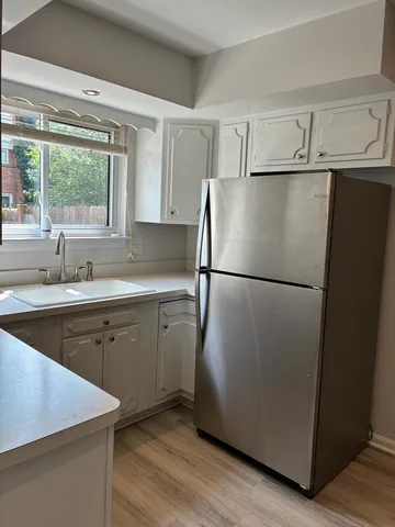 a kitchen with a refrigerator sink and cabinets