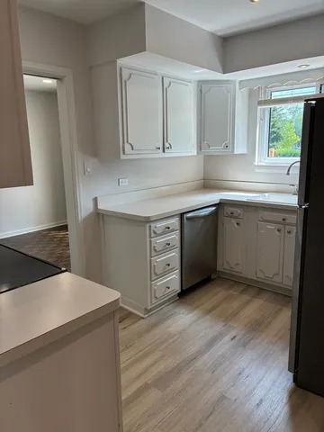 a kitchen with sink cabinets and wooden floor