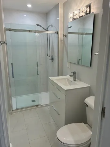 a bathroom with a sink a toilet and shower