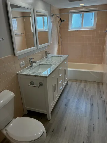 a bathroom with a granite countertop toilet sink and mirror