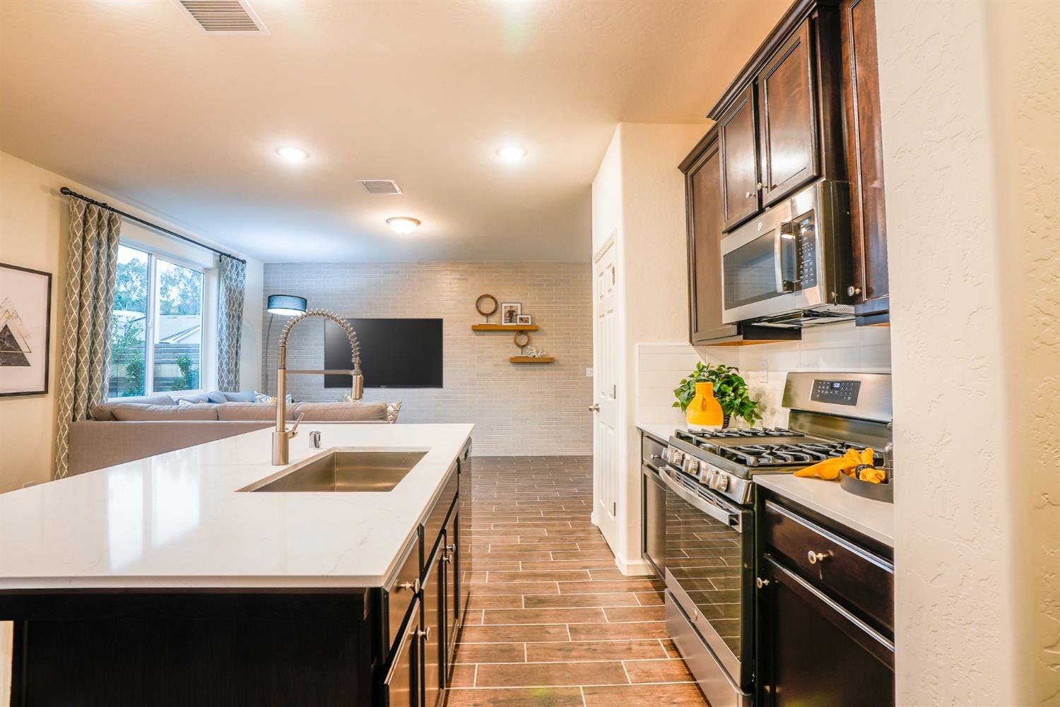 2329 North Raleigh Drive Fresno, CA 93727 - Photo 11 of 25 a kitchen with stainless steel appliances a sink a stove and cabinets