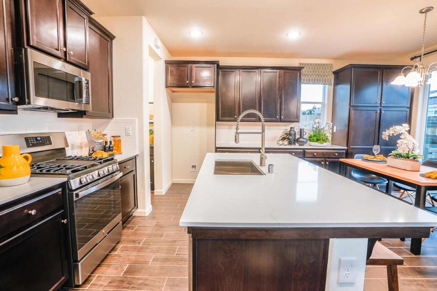 2329 North Raleigh Drive Fresno, CA 93727 - Photo 7 of 25 a kitchen with stainless steel appliances a stove a sink and a microwave