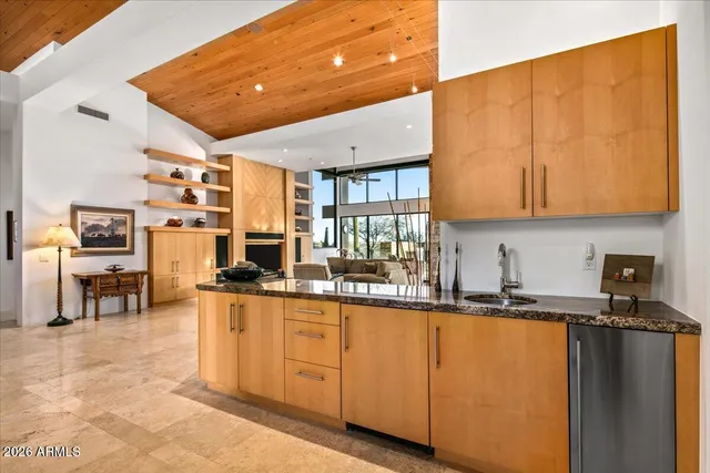a dining hall with granite countertop a sink and a refrigerator