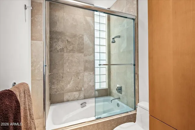 a bathroom with a granite countertop sink a toilet and a mirror