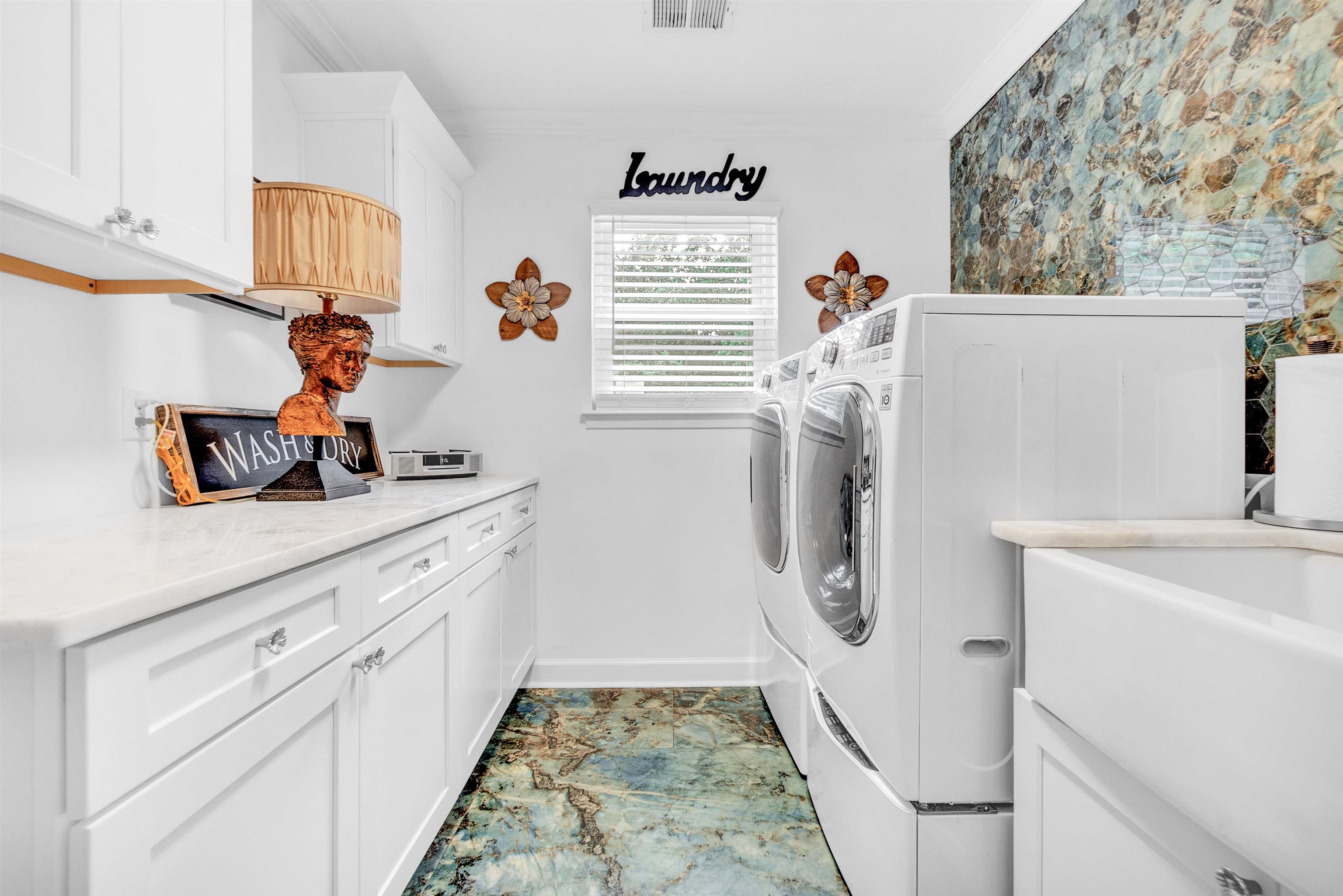 3029 Andy Road Memphis, TN 38109 - Photo 12 of 21 Washroom with separate washer and dryer, cabinet space, crown molding, baseboards, and marble look tiles