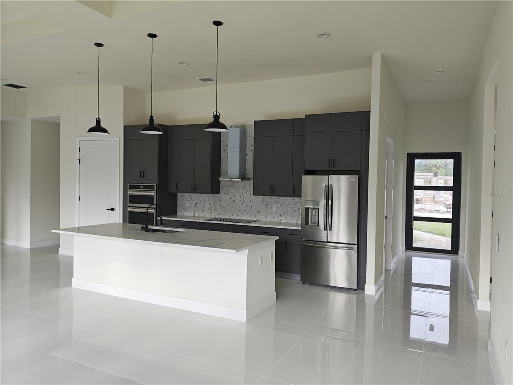 267 Santa Marta Street Port Charlotte, FL 33954 - Photo 3 of 13 a kitchen with stainless steel appliances kitchen island granite countertop a refrigerator a oven and a stove with granite countertops