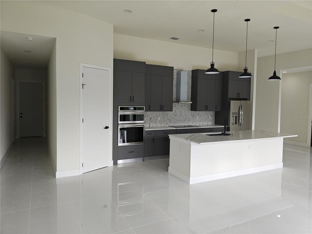 267 Santa Marta Street Port Charlotte, FL 33954 - Photo 4 of 13 a large kitchen with kitchen island a counter top a stove a sink and a refrigerator