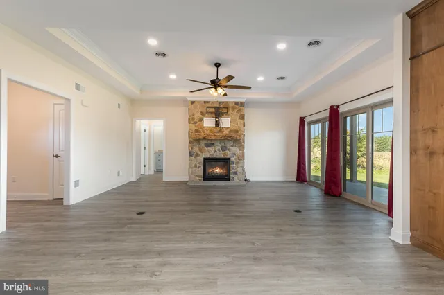 an empty room with windows and fireplace