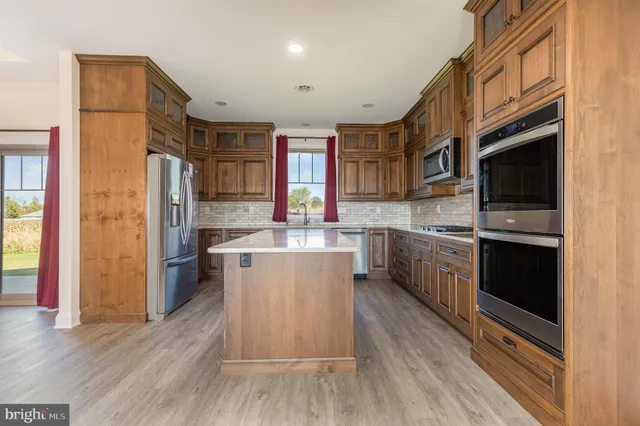 a kitchen with a sink cabinets stainless steel appliances and a window