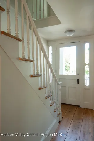 a view of entryway and hall with wooden floor