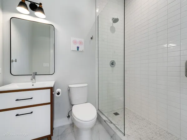 a bathroom with a toilet sink vanity and mirror