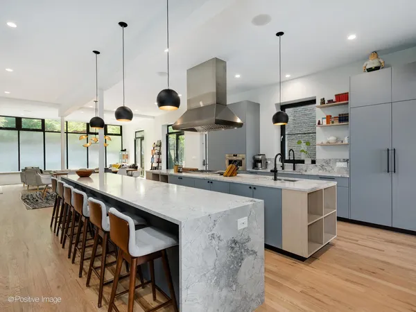 a kitchen with stainless steel appliances granite countertop a sink a stove and a wooden floor
