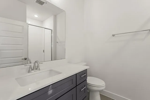 a bathroom with a sink a toilet and mirror