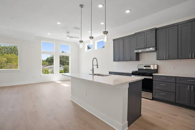 a kitchen with a sink stove and cabinets