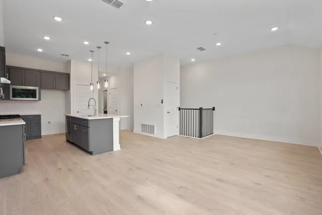 a large white kitchen with a sink stainless steel appliances and cabinets