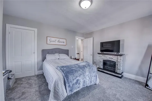a spacious bedroom with a bed and a flat screen tv