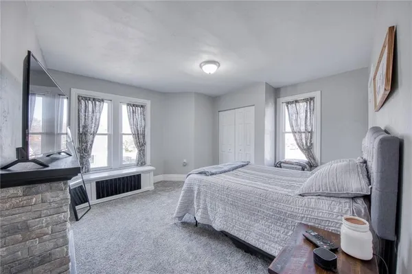 a spacious bedroom with a bed and wooden floor