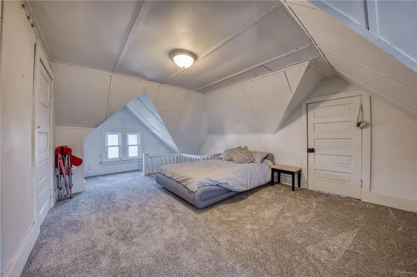 a spacious bedroom with a bed and a chandelier