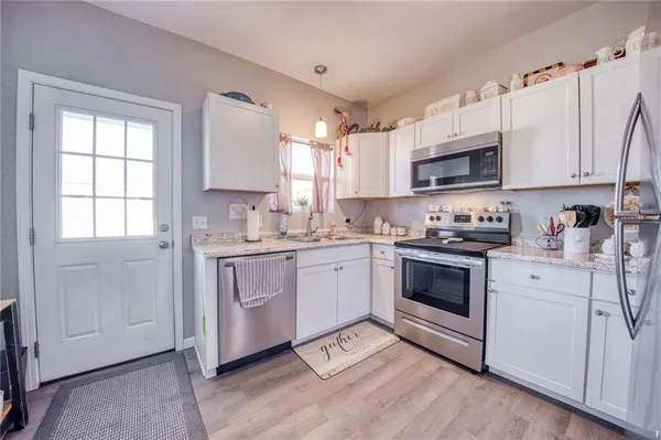 a kitchen with granite countertop white cabinets and white appliances
