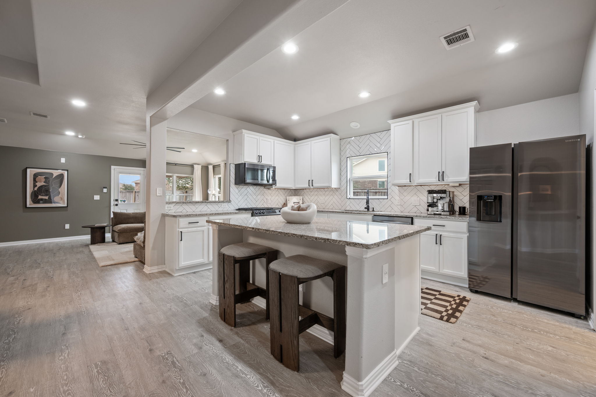 3724 Brean Down Road Pflugerville, TX 78660 - Photo 3 of 34 a kitchen with stainless steel appliances granite countertop a sink a stove a refrigerator cabinets and chairs
